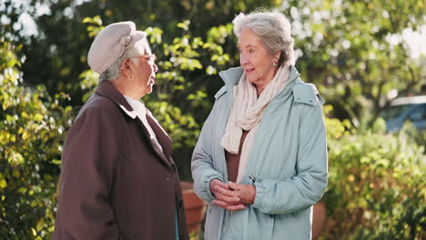 two senior women talking in a garden