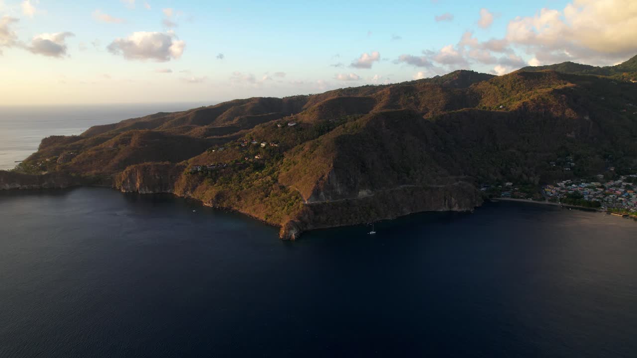 Aerial Drone Footage Captures The Stunning Petit Piton In St. Lucia At Sunset. The Vibrant Hills Transition From Green To Orange, While The Dark Blue Caribbean Sea Glistens Under A Clear Sky.