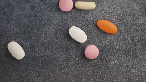 different colored pills on a dark surface