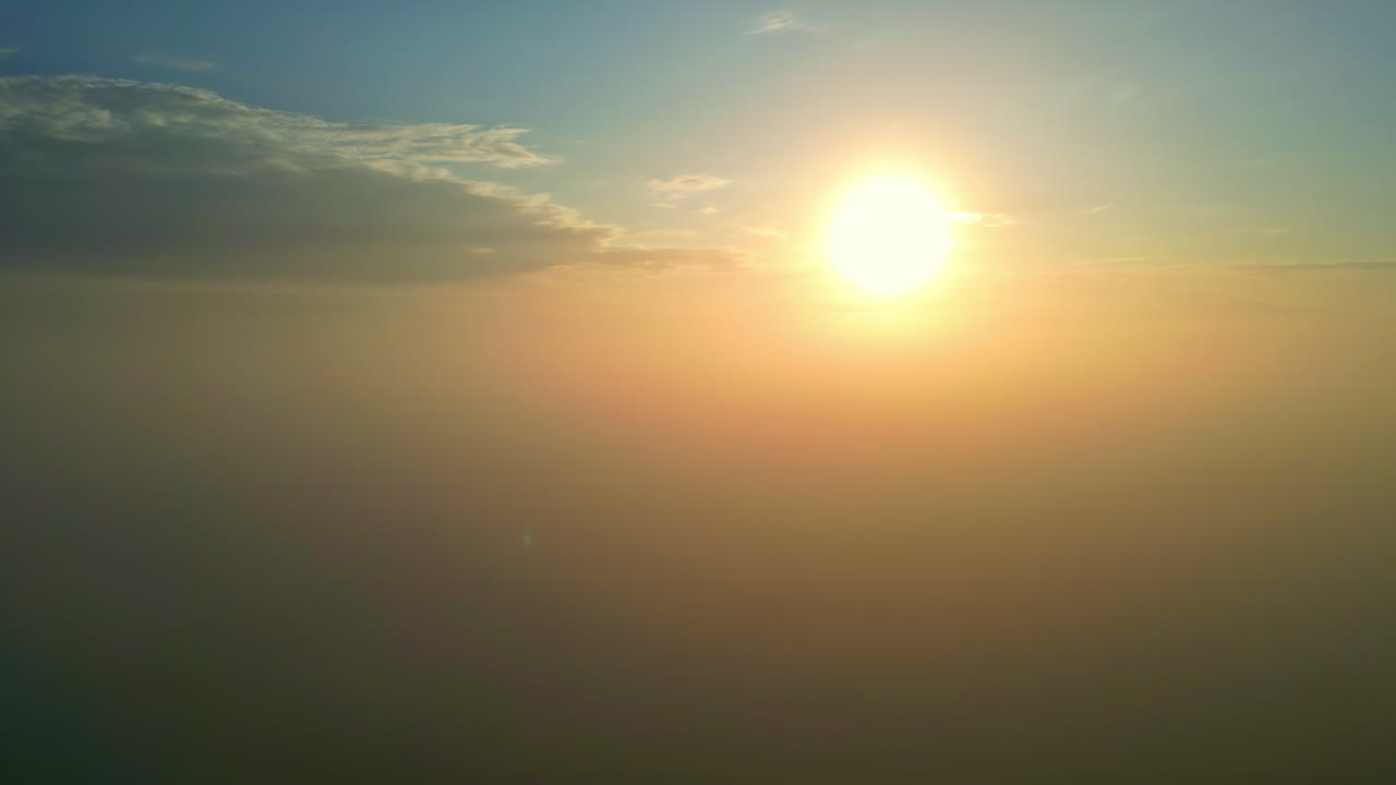 drone paisaje aéreo de la hermosa madrugada puesta de sol dorada rayos del amanecer rompiendo sobre el horizonte con niebla niebla bruma nubes en el cielo vívido clima tiempo al aire libre naturaleza