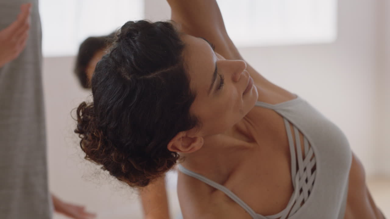 clase de yoga hermosa mujer hispana practicando pose triangular instructor de fitness enseñando a un grupo de mujeres multiétnicas práctica de meditación saludable en un estudio de entrenamiento