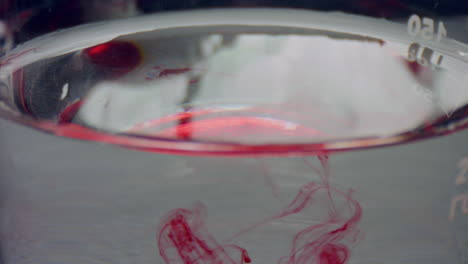 Red-liquid-dropping-in-flask.-Closeup-blood-drops-flowing-in-water