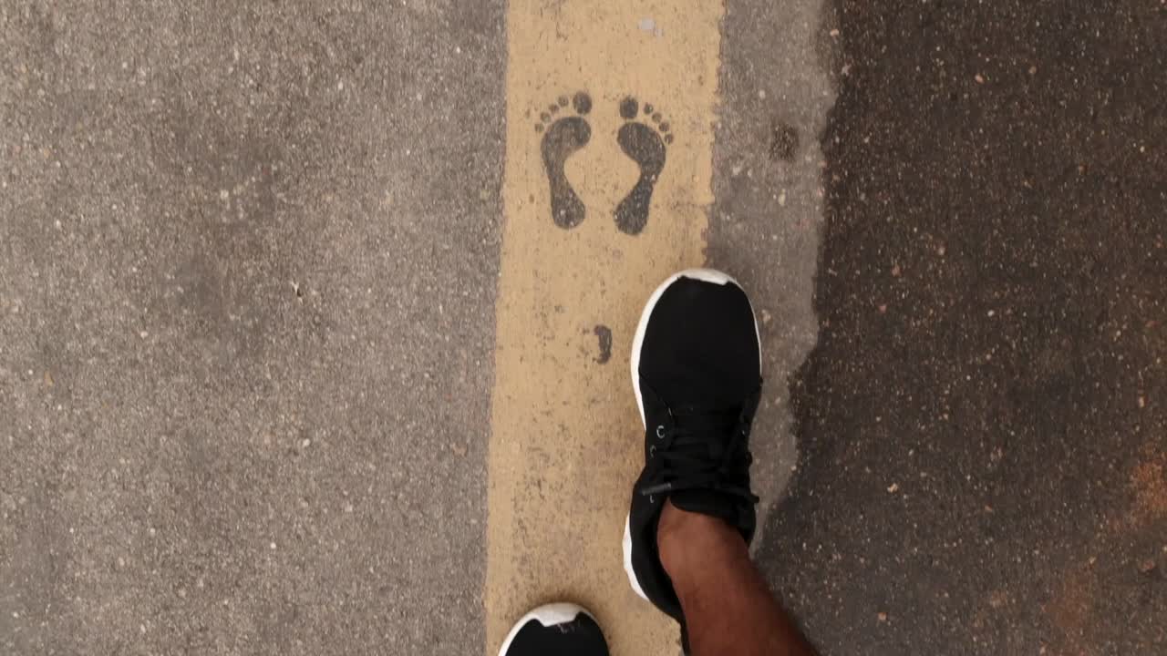 Point of view shot of a person walking on asphalt yellow line during alcohol test at a checkpoint