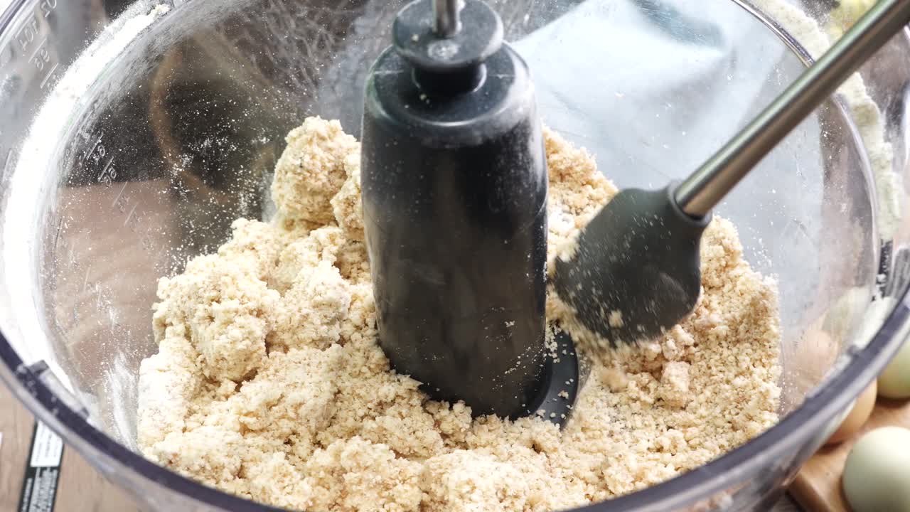 Using a food process or blender to make a dessert crust. Close up of mixing baking ingredients to make a dessert with a pie crust. Making brownies with a food processor for dessert.