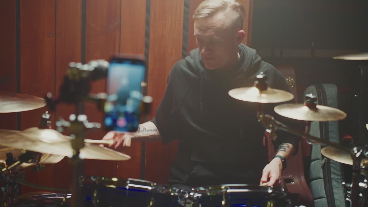 Drummer recording a music tutorial video in a studio