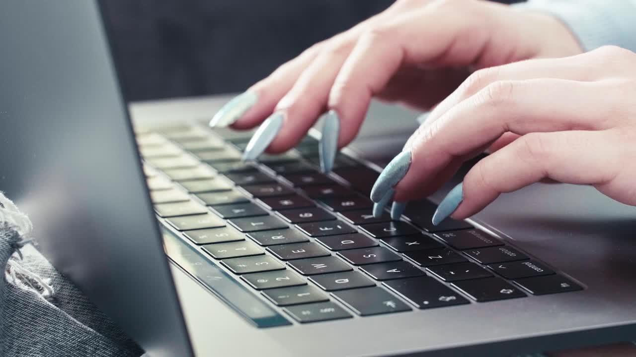 mãos de secretária com unhas compridas digitando em um laptop moderno com palavras-chave, close-up em câmera lenta de uma mulher caucasiana trabalhando on-line