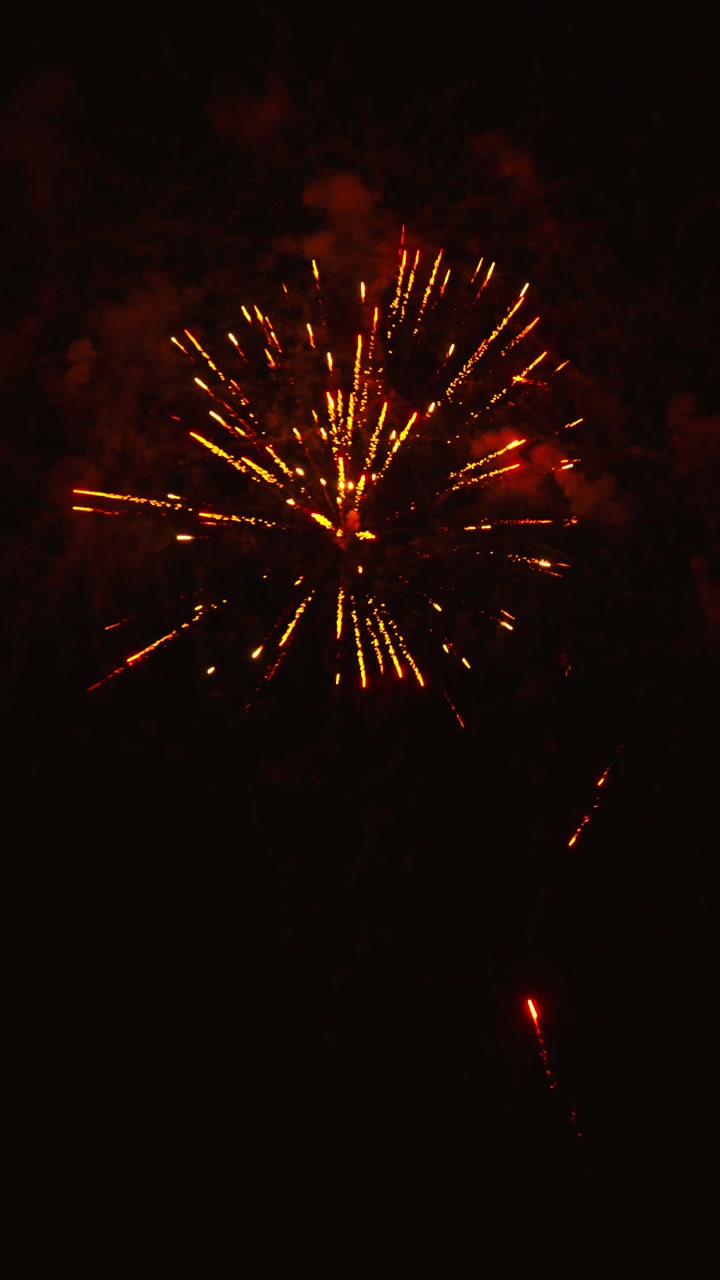 Vivaci fuochi d'artificio dorati che esplodono nel cielo notturno
