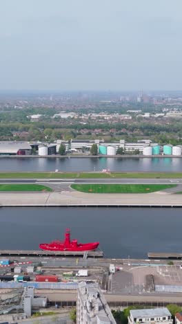 vertical drone pan left by london city airport, with houses, car park and runway