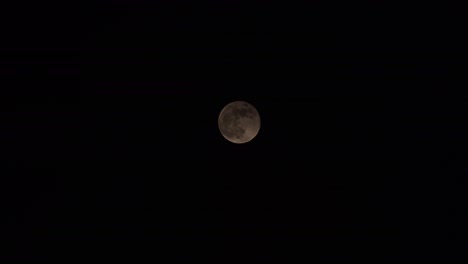 las nubes pasan delante de la luna llena en la noche oscura