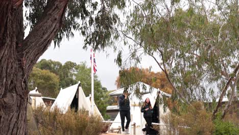 visitors exploring historical site with tents and trees