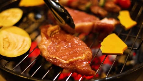 grilling steak and vegetables over charcoal flames