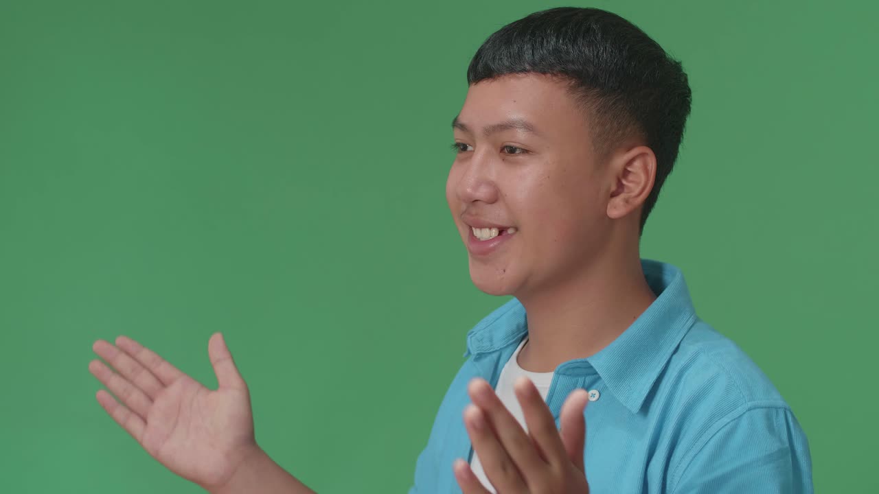 Tampak Samping Anak Laki-Laki Asia Muda Meniup Ciuman Ke Kamera Di Studio Layar Hijau.
