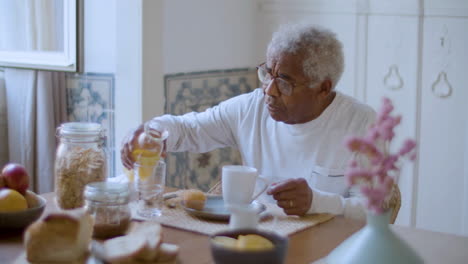 black elderly man enjoying breakfast at home.