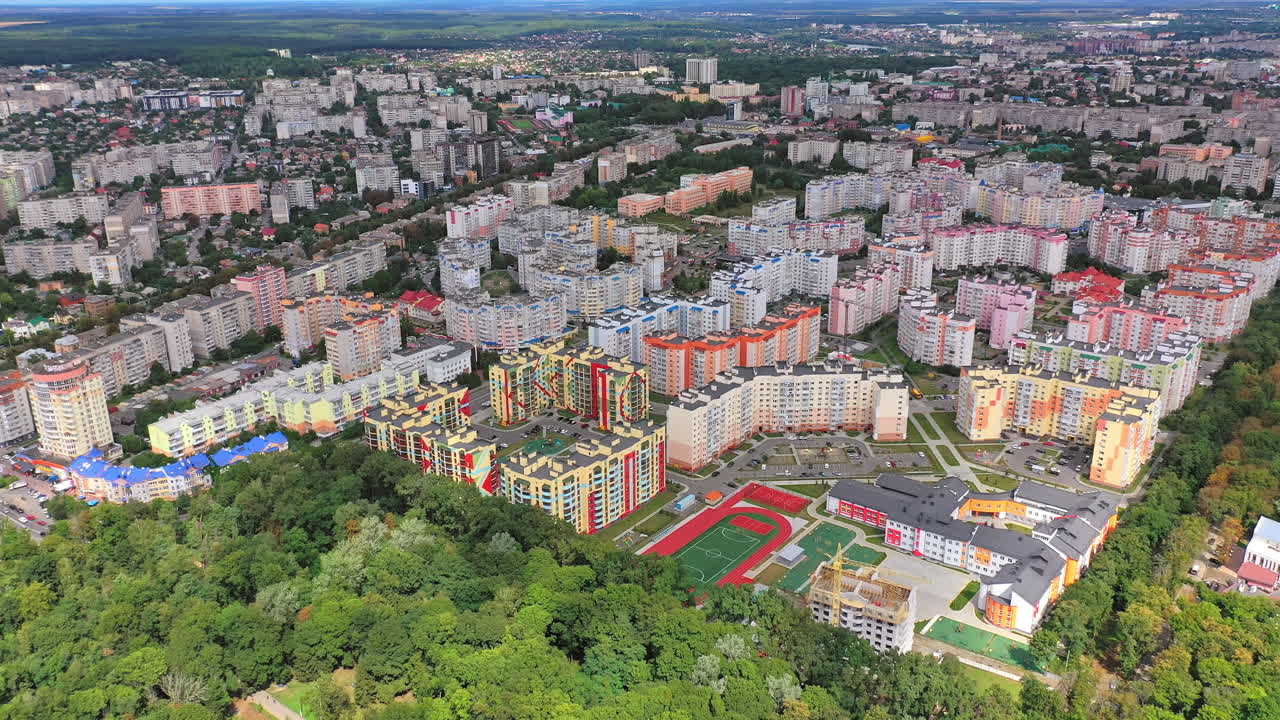 Modern city district near the forest. New apartment buildings of residential complex. High-rise apartments newly built near green plantings. Aerial view.