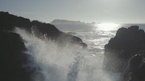 static slow motion close up shot of an ocean wave smashing on rock and splashing water in the air