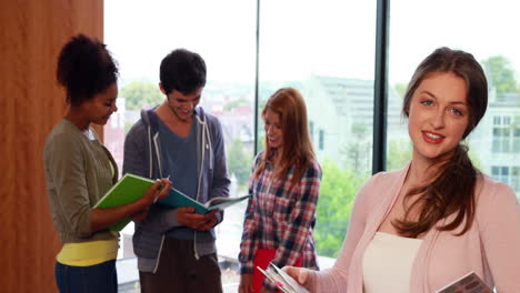 estudiante sonriendo a la cámara en la biblioteca