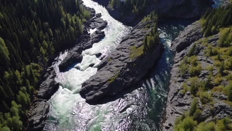 aerial view of a river flowing through a rocky forested canyon with rapids