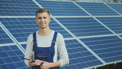 portrait of a young worker in workwear smiling and looking at the camera against the background of s