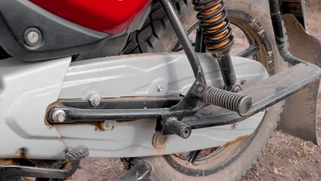 close up side view of the chain guard and rear wheel of a bajaj motorcycle from india imported to africa