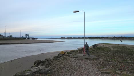 Farola-Solitaria-Inusual-Con-El-Hombre-Apoyado-En-El-Estuario-Del-Río-Wyre-Fleetwood-Lancashire-Uk