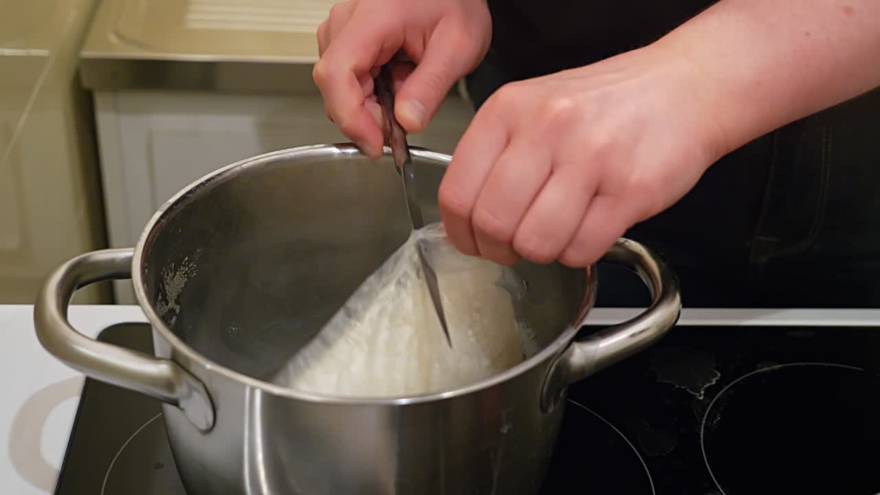 la bolsa de arroz se abre con un cuchillo y se vierte en una cacerola