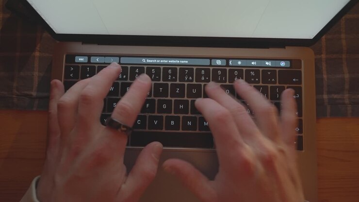 Top down shot of laptop keyboard layout while man type on it ring on finger