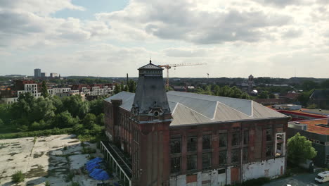 la antena circular de un edificio histórico abandonado con la torre del reloj revela gante en el fondo