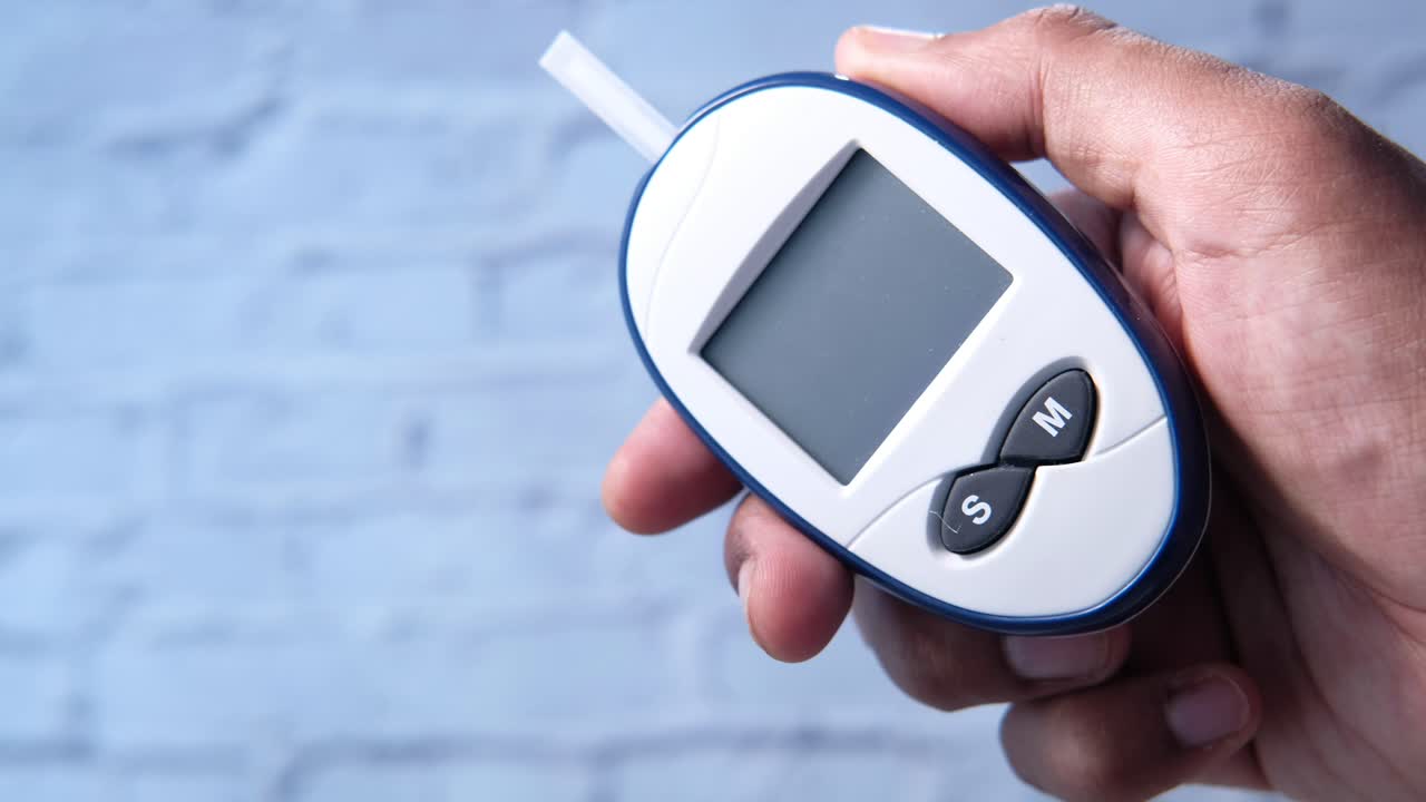 Blood Glucose Meter in Hand