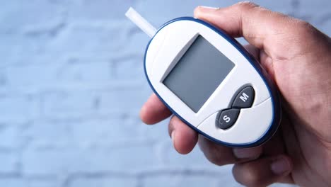 blood glucose meter in hand