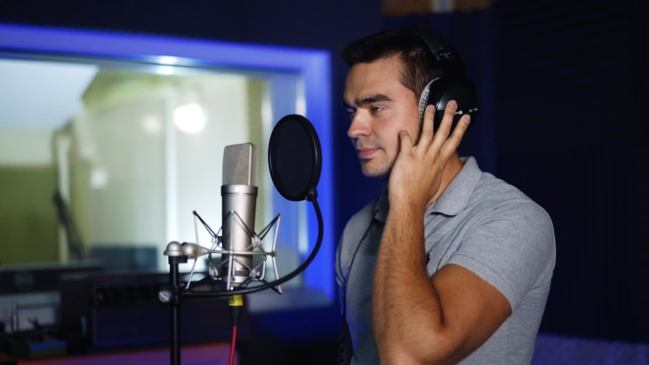 hombre cantando en un micrófono en un estudio de grabación