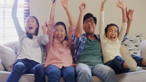 Excited-family-watching-television-together-in-living-room-4k