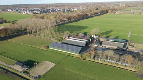 aerial overview of a farm with solar panels on roof of barn in rural holland