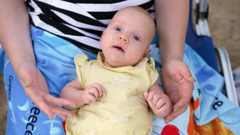 bebé de tres meses en el regazo de la madre