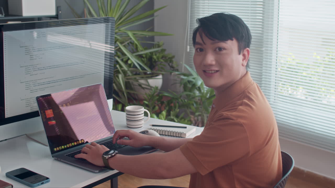 Asian Coder Smiling at Camera when Developing App for Computers