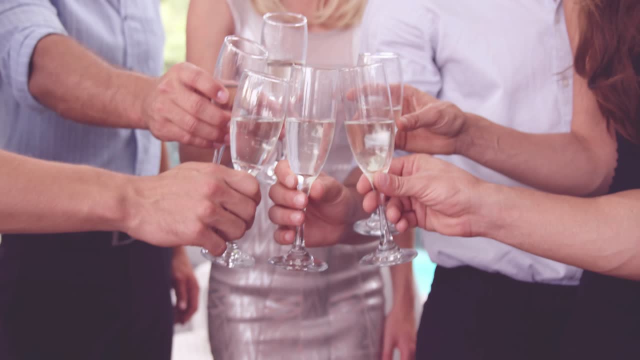 Six adults clinking flutes clinking causing confetti overlay camera pulling back celebrating events