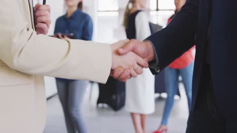 Businessmen-shaking-hands-in-conference-room