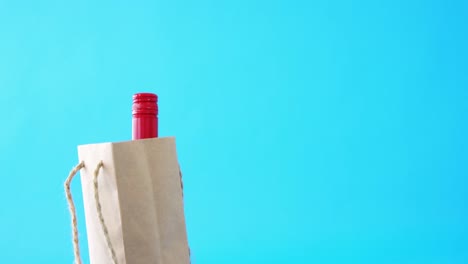 Bottle-in-shopping-bag-on-blue-background