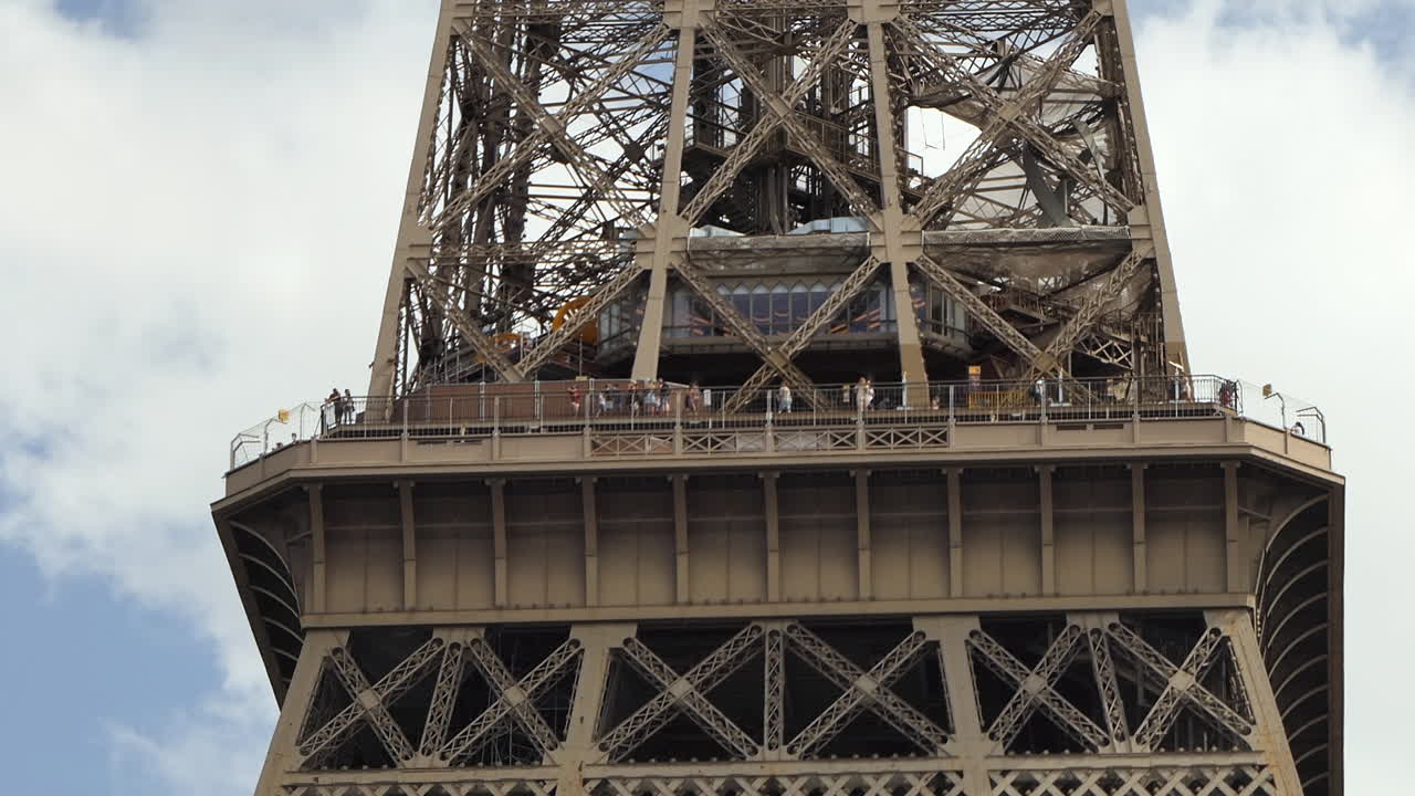 Eiffel tower in Paris, Close-up of the second floor viewpoint full of tourists, Low angle view from the ground