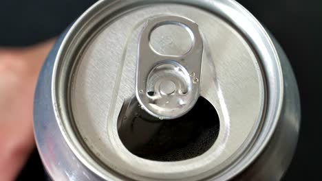 male opening unmarked soda can of fizzy cola close up