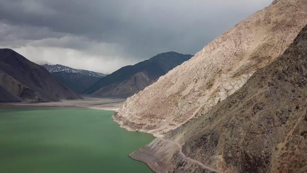 Yeso Dam, Chile. Aerial View of Green Water Reservoir Under Naked Rocky Hills of Andes Mountains and Dramatic Sky