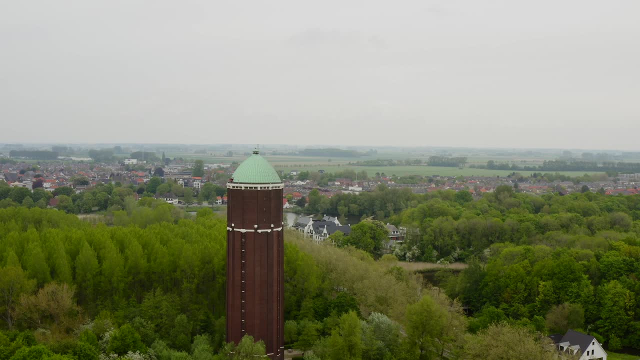 Aerial orbit over the famous water tower in the city of Axel shot on a cloudy day with city panorama in behind