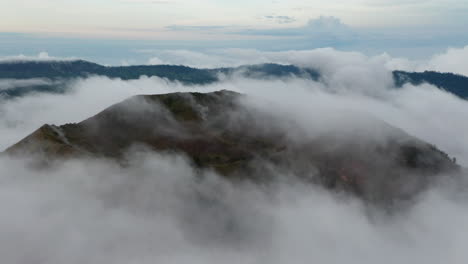 Langsame-Luftaufnahme-Von-Dichten-Nebelwolken,-Die-Einen-Batur-berg-In-Einem-Tropischen-Klima-Auf-Der-Insel-Bali-Umgeben