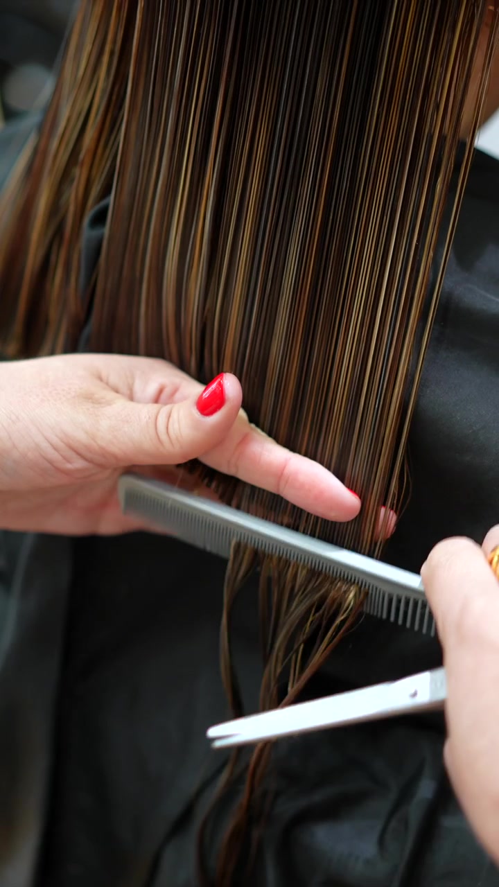 Parrucchiere professionista che taglia i capelli a un cliente in salone