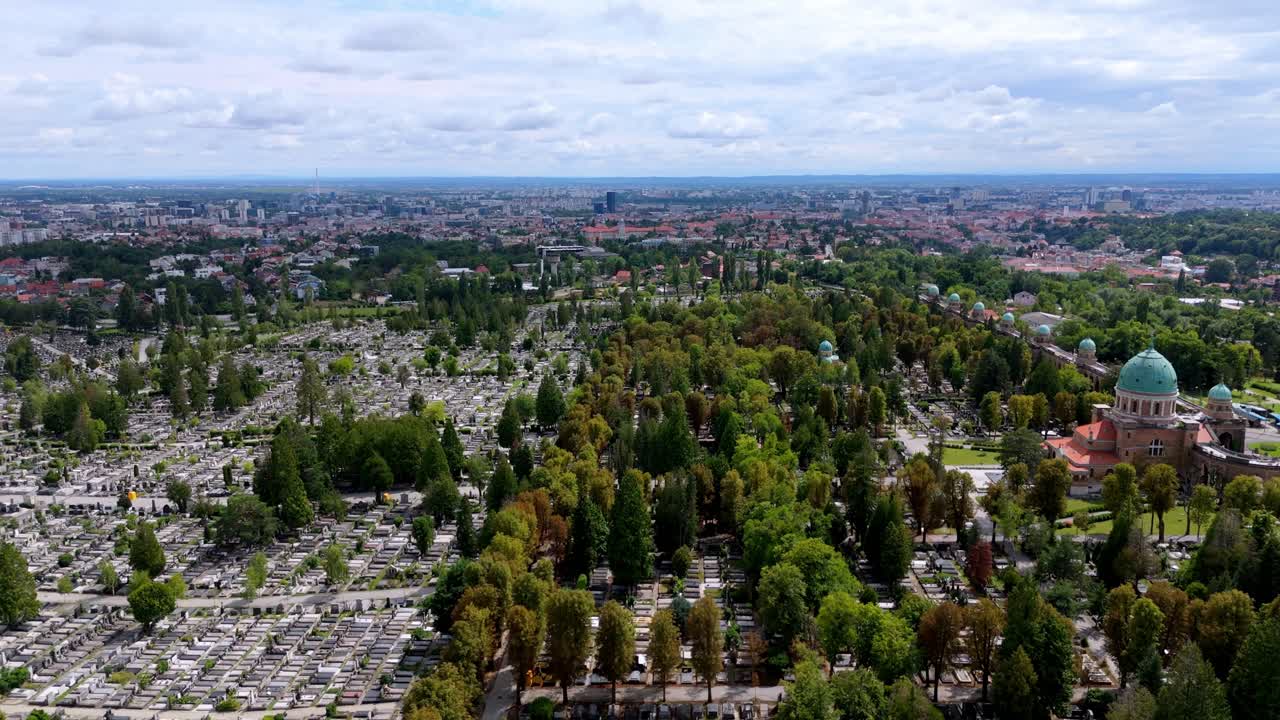 Aerial drone view of Mirogoj Cemetery in Zagreb, Croatia, featuring green domes, ivy-covered arcades, and symmetrical paths a masterpiece of European funerary art. zoom out aerial