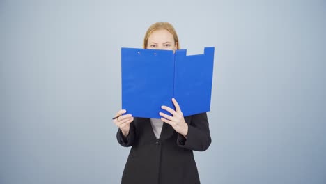 business woman looking from behind files.