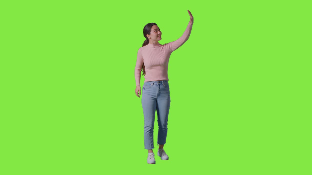 Full Length Studio Shot Of Woman Looking All Around And Interacting With VR Environment Against Green Screen 1