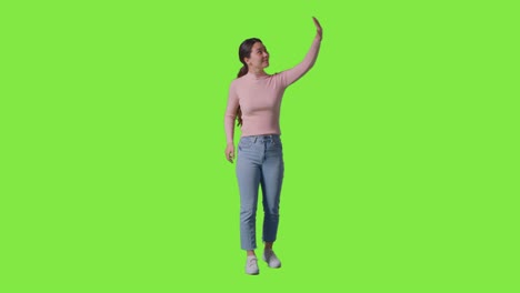 Full-Length-Studio-Shot-Of-Woman-Looking-All-Around-And-Interacting-With-VR-Environment-Against-Green-Screen-1