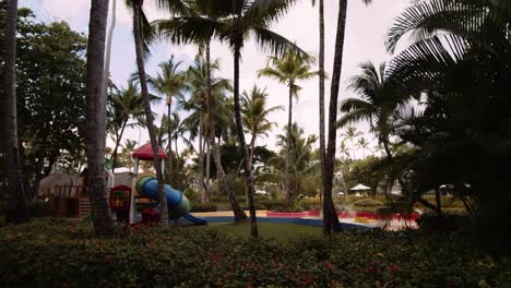 colorful kids play zone amongst palm trees in tropical resort; slomo