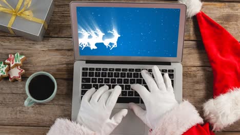 santa using laptop with christmas sliegh and reindeers