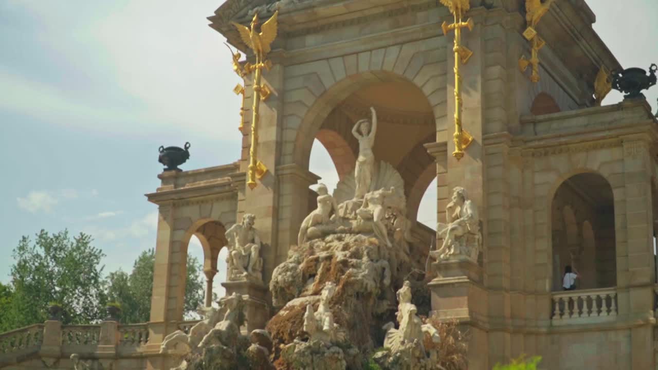 Stunning footage of a young caucasian girl in a green dress and hat joyfully posing in front of Cascada Monumental - Gaud&iacute;'s fountain in Parc de la Ciutadella